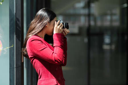 Side view, Female taking picture with professional vintage camera in the studio. female photographer.の写真素材