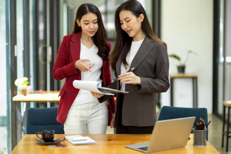 A professional female executive provides advice and mentoring on the work project of her staff in the modern office.の写真素材