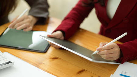 Two of marketing team making marketing plans on modern digital tablet together and spending time in officeの写真素材