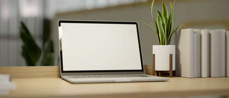 Close-up Simple home working space with laptop computer blank screen mockup, minimal plant in pot and books on wood table. 3d rendering, 3d illustrationの写真素材