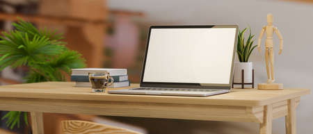 Close-up computer desk with laptop computer blank screen mockup and decor on wooden table over blurred home office background. 3d rendering, 3d illustrationの写真素材
