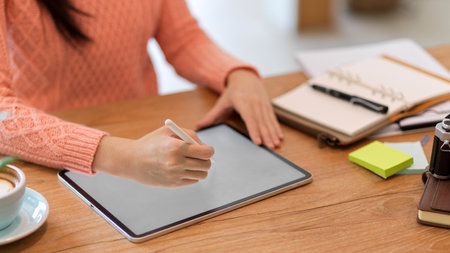 Cropped A female freelance graphic designer works on a digital tablet computer to create her graphics. Mockup of a blank tablet screen.の写真素材