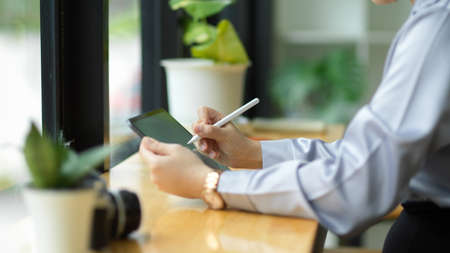cropped image of female accountant using digital tablet and stylus pen to calculate and analyse data.の写真素材