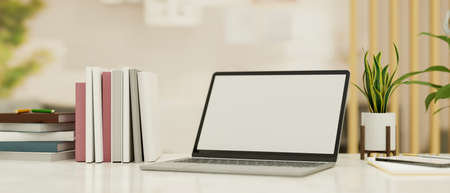 Close-up Modern office working desk with laptop computer blank screen mockup, books and decor in modern office interior. 3d rendering, 3d illustration.の写真素材
