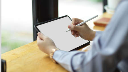 Successful businesswoman using stylus pen to create her presentation on digital tablet computer. tablet blank screen mockup.の写真素材