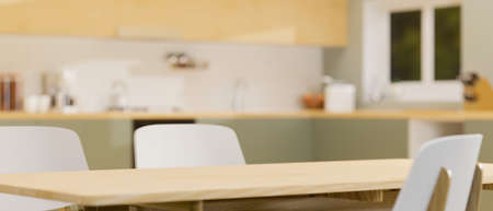 Modern wooden dining table with space on top for montage product display over blurred stylish kitchen interior in background. 3d rendering, 3d illustrationの写真素材