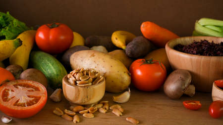 Healthy diet food ingredients background, vegetables, seeds, nuts, rice berry, fruits on wooden table. vegan, plant-based, organic.の写真素材