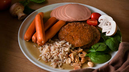 Healthy vegan meal, a plate of soy protein meat with vegan cutlet meat, sausages and bologna sausages and organic vegetables.の写真素材