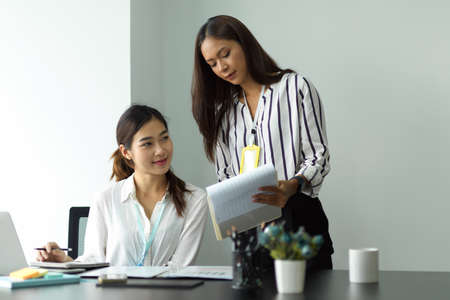 Image of Successful business female manager explaining scope of works to her new assistant in the office.の写真素材