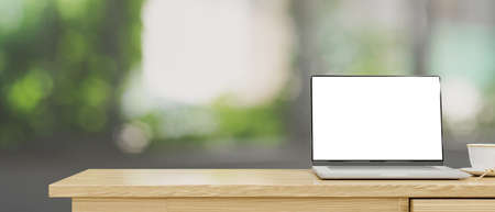 Wooden computer desk with laptop blank screen mockup and copy space for product display over blurred bokeh green background. 3d rendering, 3d illustrationの写真素材