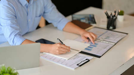 Male executive manager working in his office, writing something on notebook. cropped shot.の写真素材