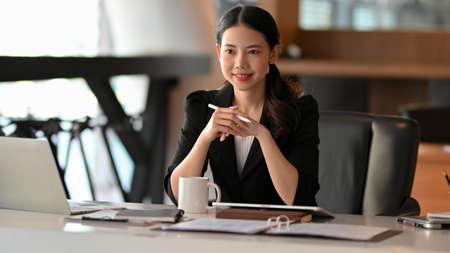 Confident businesswoman, business entrepreneur sitting and listening her employee presenting project in the meeting.の写真素材