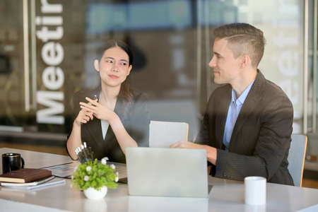 Intelligent businessman having a outdoor meeting with his business female partner in co-working space at coffee shop.の写真素材