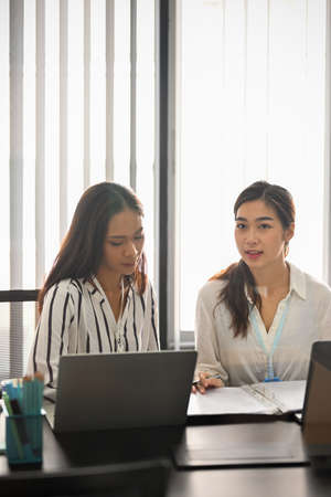 Portrait of two businesswomen in meeting room sharing their ideas and discuss the solutions to improve business sale.の写真素材