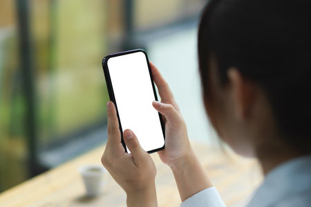 Smart mobile phone, cellphone blank screen mockup for template in female hands, blurred background.の写真素材