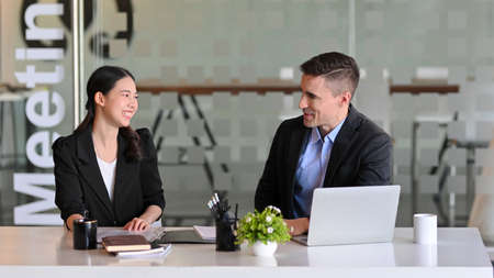 Happy business colleagues having a small meeting in modern conference room. diverse coworker.の写真素材