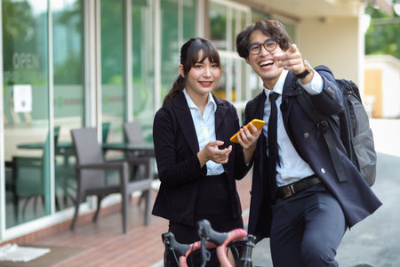 Asian businessman giving a directions advice to young female at the city street.の写真素材