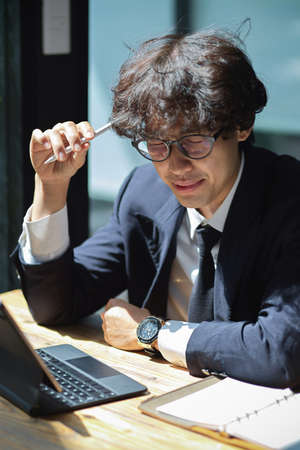 Busy businessman executive manager, overworked and thoughtful for creative ideas for his business.の写真素材