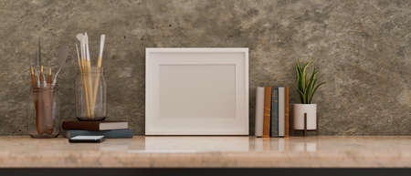 White picture frame mockup stand on vintage marble table with painting tools and decor over grunge loft wall. 3d rendering, 3d illustrationの写真素材