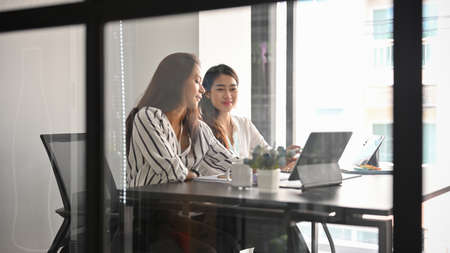 Businesswoman working with her female colleagues, planning project in meeting room.の写真素材