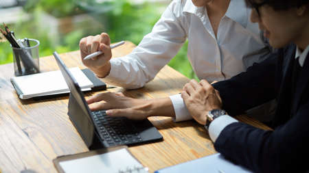 Close-up employee in business analyst team discuss and analyse some data on digital tablet computer.の写真素材