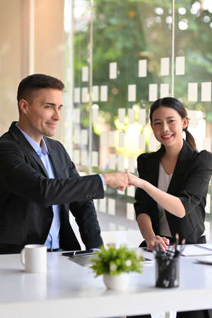 Happy diverse business people giving a first bump for celebration successful business deal in officeの写真素材
