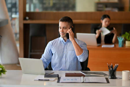 Businessman calling to his business partner company to remind the conference meeting date. male broker on the phone with client.の写真素材