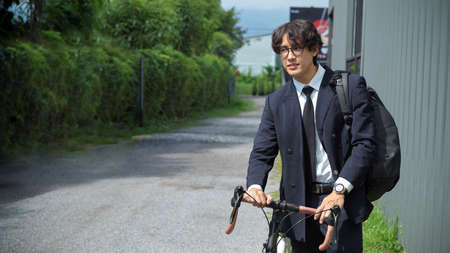 Businessman in business suit riding on bicycle lane to work on urban city street in the morning.の写真素材