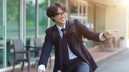 Happy businessman in business suit riding bicycle to work in the morning. e-co friendly transports.の写真素材