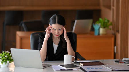 Stressed business female entrepreneur working in the office. headache, tired, depressed, overworked.の写真素材