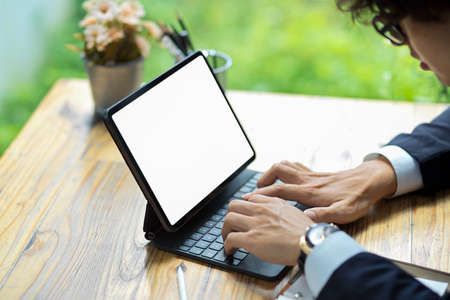 Close-up Businessman, male executive manager working on his digital tablet and typing on keyboard.の写真素材