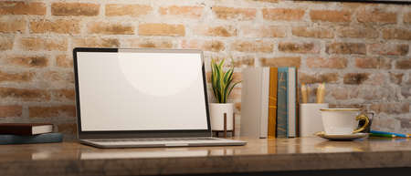 Contemporary vintage workspace with laptop empty screen mockup and supplies on marble table over brick wall. 3d rendering, 3d illustrationの写真素材