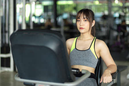 Gorgeous strong fitness woman in sportswear exercise workout on riding fitness machine at the gym.の写真素材