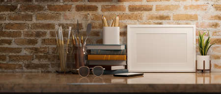 Mockup picture poster frame in home worktable with decor over vintage brick wall background. 3d rendering, 3d illustrationの写真素材