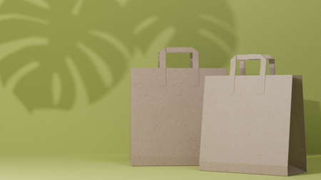 Brown paper shopping bags, fashion shopping bags on green background with leaf shadows. 3d rendering, 3d illustrationの写真素材