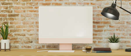 Modern vintage contemporary workspace with modern computer blank screen mockup and decor on wooden table over brick wall. 3d rendering, 3d illustrationの写真素材