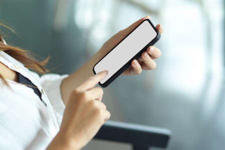 Side view, Businesswoman using mobile application via modern smartphone. smartphone blank screen mockupの写真素材