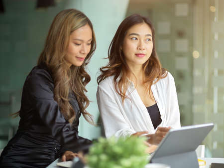 Two female marketing staff members are discussing and preparing marketing content for the next meeting.の写真素材