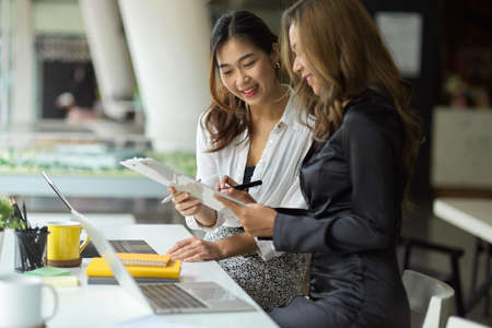 Two of confident young female in marketing team working and planning marketing project together in office.の写真素材