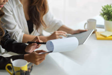 Cropped image of two colleagues working together to analyze data and plan the business's financial...