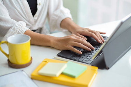 Cropped, closeup image of Successful businesswoman working, typing on modern portable tablet keyboard.の写真素材