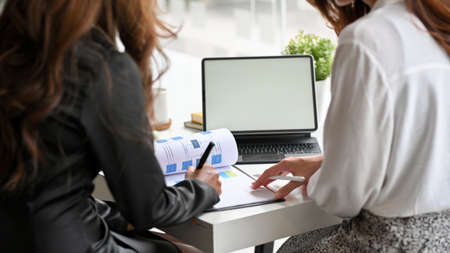 Two female in marketing team working and planning new project advertising together. tablet computer blank screen mockup.の写真素材