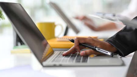 Cropped and closeup image of Businesswomen hands typing, using, working on laptop computer at officeの写真素材