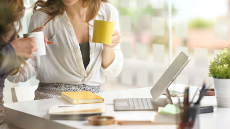 Cropped image of happy employees having a good time chatting during a coffee break at the office.の写真素材