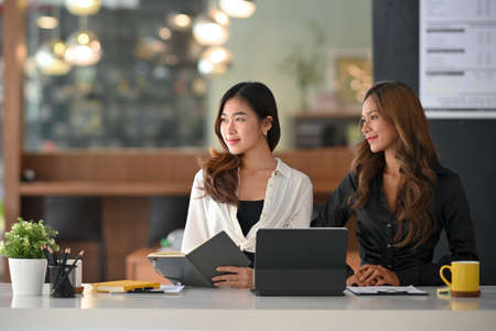 Two elegant female executives are interviewing a new job candidate in board room. Human Resources manager.の写真素材
