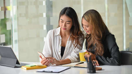 Two close-friends college students working and doing homework together at library co working space.の写真素材