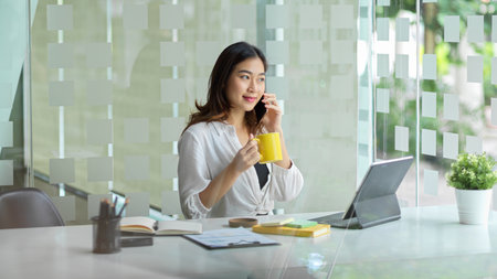 A successful executive female is on the phone with a business partner to negotiate the cost of a product.の写真素材