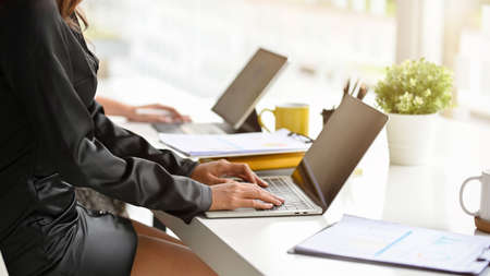 Cropped shot of hard working women analyse financial data on laptop computer at their workspace in modern office room.の写真素材