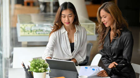 Attractive female financial banking broker holding a casual meeting with a client in the office co working space.の写真素材