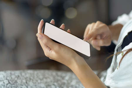 Side view, closeup, Young woman use mobile phone, text message on smart phone, smartphone with blank...